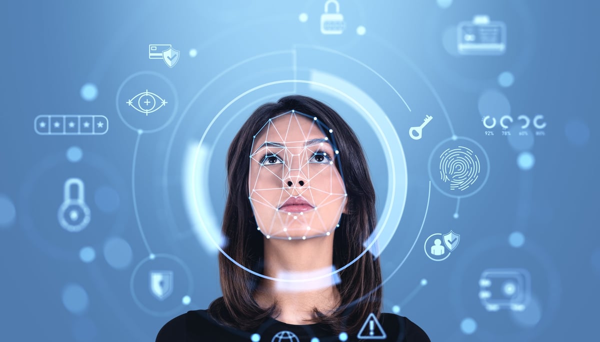 Woman looking at futuristic facial recognition interface with biometric icons